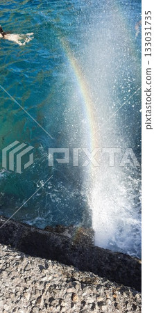 A rainbow emerges when it rains. rainbow with splashing water of a sea. Art of Nature Rainbow in water droplets.  133031735
