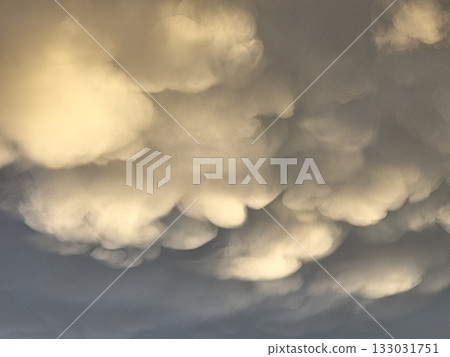 Storm clouds on sunset. Light in the dark and dramatic storm clouds. Background of storm clouds before a thunderstorm. Mammatus clouds 133031751