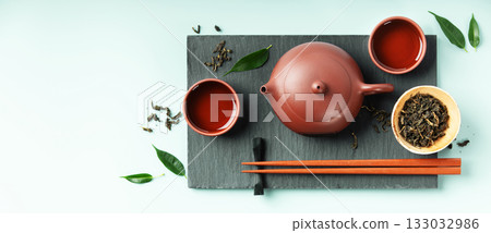Asian Tea Ceremony Banner with Red Clay Teapot and Green Leaves Asian Tea Ceremony Banner with Red Clay Teapot and Green Leaves 133032986