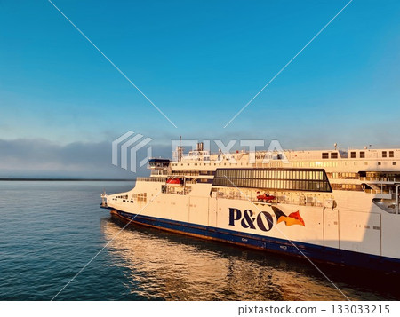 PO ferry ship sailing across calm sea during golden hour with clear blue sky PO ferry ship sailing across calm sea during golden hour with clear blue sky 133033215