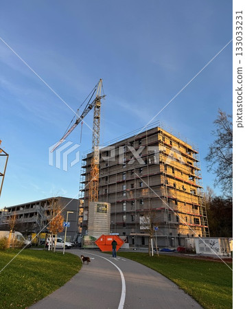 Construction Site with Crane and Scaffolding at Sunset 133033231