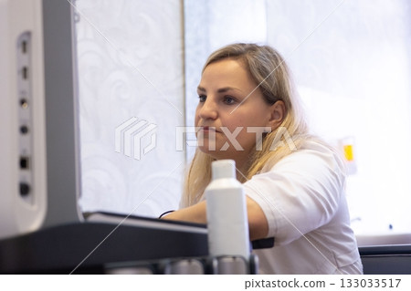 Medical professional viewing diagnostic imaging. Close-up of a doctor in a medical facility looking at a monitor, analyzing results. 133033517