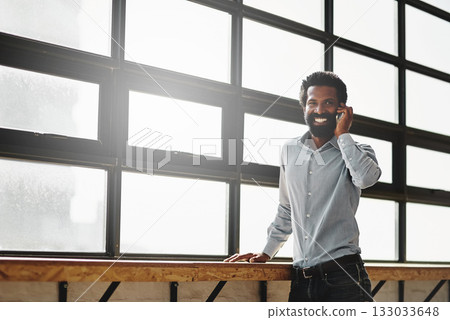 Window, smile and phone call with a business man talking in the office while networking for negotiation. Happy, mobile and communication with a happy male employee standing at work during his break Window, smile and phone call with a business man talking in the office while networking for negotiation. Happy, mobile and communication with a happy male employee standing at work during his break 133033648