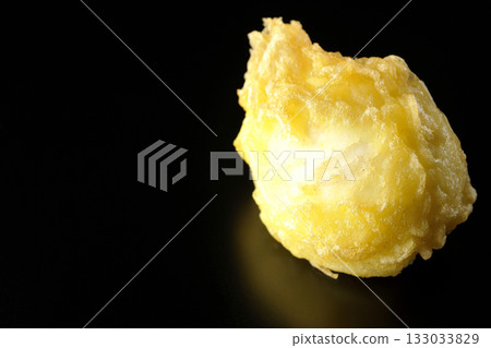 Egg tempura photographed alone against a black background 133033829