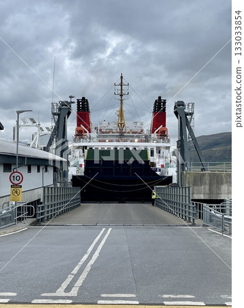 Large car and passenger ferry docked at port terminal ramp ready for loading 133033854