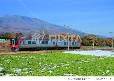 The SR1 series train gazes up at Mount Asama in autumn, its leaves turning a brilliant red. The SR1 series train gazes up at Mount Asama in autumn, its leaves turning a brilliant red. 133033883