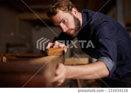 Contractor, wood sanding and man in workshop working on building construction and architecture. Home improvement, maintenance and handyman work of a male employee with carpentry tool for woodwork 133034138