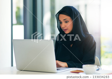 Woman, muslim and laptop for career is working at the office on the internet for dubai and technology. Professional, computer and arabic with a hijab is on the web to design at a company with tech. Woman, muslim and laptop for career is working at the office on the internet for dubai and technology. Professional, computer and arabic with a hijab is on the web to design at a company with tech. 133034283