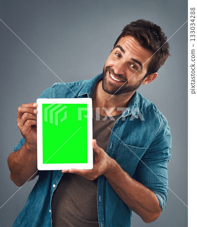 Happy man, portrait and tablet with green screen for advertising, marketing or branding against a grey studio background. Male person showing technology display, chromakey or mock up in advertisement Happy man, portrait and tablet with green screen for advertising, marketing or branding against a grey studio background. Male person showing technology display, chromakey or mock up in advertisement 133034288