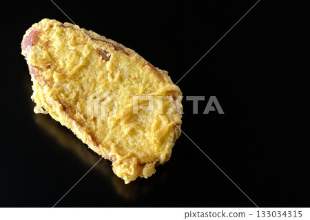 Sweet potato tempura photographed alone against a black background 133034315