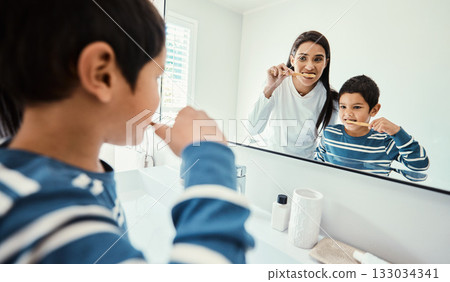 Happy family, woman and boy in bathroom for brushing teeth, healthcare and bonding to start morning in house. Young kid, mother and teaching with toothbrush, smile and mirror for medical self care Happy family, woman and boy in bathroom for brushing teeth, healthcare and bonding to start morning in house. Young kid, mother and teaching with toothbrush, smile and mirror for medical self care 133034341