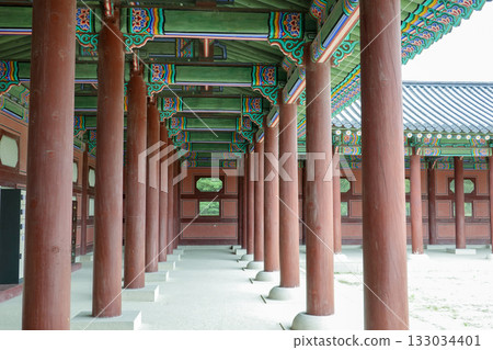 Traditional Korean Exterior Corridor with Vibrantly Painted Wooden Columns and Intricate Dancheong Patterns in Historic Palace Architecture 133034401