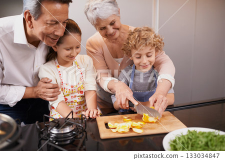 Food, happy children or grandparents teaching cooking skills for a healthy dinner with fruit or vegetables at home. Kids learning, knife or grandmother with old man or diet meal nutrition in kitchen 133034847