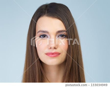 Hair, beauty and portrait of woman with makeup, cosmetics and skincare products on blue background. Salon aesthetic, dermatology and face of girl in studio for wellness, spa treatment and facial care 133034949
