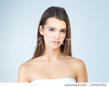 Beauty, skincare and serious with portrait of woman for cosmetics, self care and glow. Natural, satisfaction and makeup with cute girl model for confident, glow and attractive on blue background 133034950