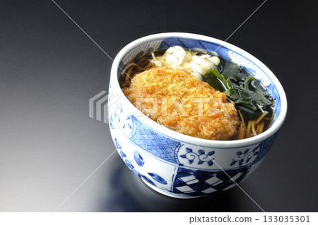 Kakesoba noodles with croquettes photographed against a black background 133035301