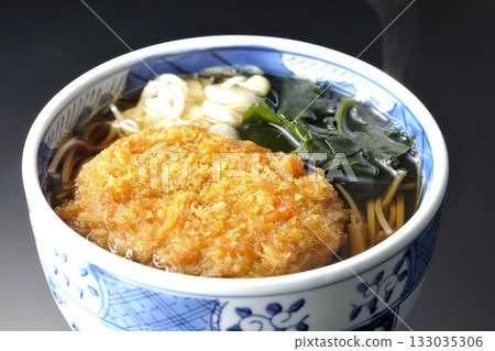 Kakesoba noodles with croquettes photographed against a black background 133035306