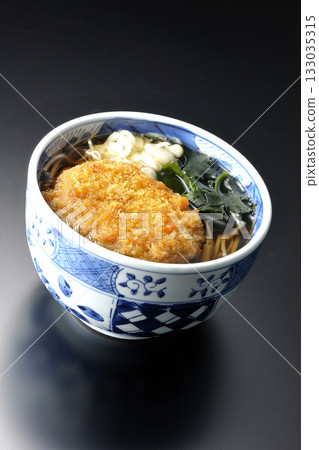 Kakesoba noodles with croquettes photographed against a black background 133035315