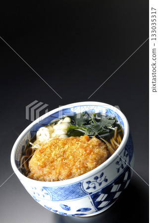 Kakesoba noodles with croquettes photographed against a black background 133035317