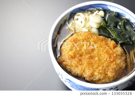 Kakesoba noodles with croquettes photographed against a black background 133035328