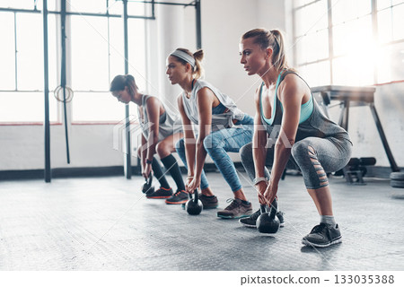 Kettlebell, training and women with workout, exercise and performance for wellness, healthy lifestyle or self care. Female athletes, friends or group with gym equipment, sports and stretching routine Kettlebell, training and women with workout, exercise and performance for wellness, healthy lifestyle or self care. Female athletes, friends or group with gym equipment, sports and stretching routine 133035388