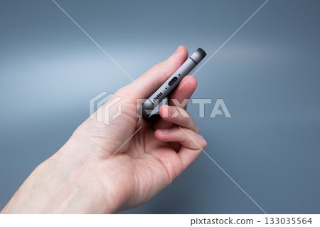 Modern smartphone with triple camera in hand on blue background for advertising Modern smartphone with triple camera in hand on blue background for advertising 133035564