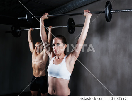 Fitness, people and weightlifting with barbell for intense training, exercise or bodybuilding at gym. Fit, active and strong woman and man lifting weight for strength, arm muscle or workout together Fitness, people and weightlifting with barbell for intense training, exercise or bodybuilding at gym. Fit, active and strong woman and man lifting weight for strength, arm muscle or workout together 133035571