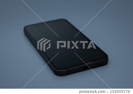 Smartphone with black screen on blue surface top view for presentation design Smartphone with black screen on blue surface top view for presentation design 133035579