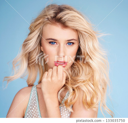 Portrait, shampoo and hair with a woman in studio on a blue background for fashion or hairstyling at a salon. Face, beauty or haircare with an attractive young female model posing for cosmetic makeup 133035750