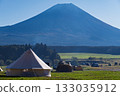 A teepee-style tent standing on a vast lawn under a clear blue sky and the majestic Mount Fuji 133035912