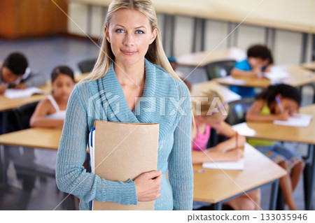Teacher, portrait and woman with binder in classroom, elementary school or class. Education, teaching and female educator with folder, paperwork or documents for serious learning, knowledge or study. 133035946