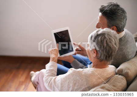 Tablet, mockup or old couple streaming movie or film on online subscription in retirement at home together. Screen, relaxing or back of senior woman loves watching fun videos with an elderly man 133035965