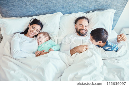 Morning, relax and happy with family in bedroom for wakeup, affectionate and bonding from top view. Smile, care and sleeping with parents and children in bed at home for playful, happiness or support Morning, relax and happy with family in bedroom for wakeup, affectionate and bonding from top view. Smile, care and sleeping with parents and children in bed at home for playful, happiness or support 133036097