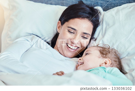 Love, baby and mother relax in bed, waking up and bonding, happy and smile together in their home. Rest, family and mom with child in a bedroom, laughing and sharing special moment of motherhood 133036102