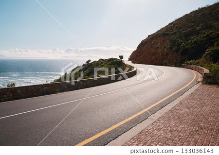 Mountain, road and ocean view with no people for travel, destination or sightseeing in Cape Town. Nature, beauty on empty street for road trip, vacation or holiday on South Africa blue sky background Mountain, road and ocean view with no people for travel, destination or sightseeing in Cape Town. Nature, beauty on empty street for road trip, vacation or holiday on South Africa blue sky background 133036143
