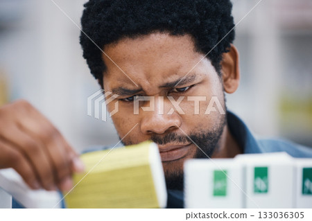 Black man, shopping or reading in pharmacy for medicine, choice or pills in retail healthcare for wellness. African customer, box or sale for health, deal or thinking for benefits of medical product 133036305