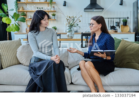 Female social worker working at home with young woman Female social worker working at home with young woman 133037194