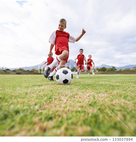 Running, kick and sports with children and soccer ball on field for training, competition and fitness. Game, summer and action with football player on pitch for goals, energy and athlete 133037894