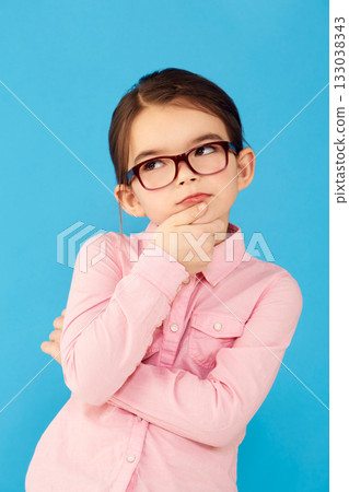 Thinking, ideas and girl with decision, choice and happiness against a blue studio background. Female child, kid and young person with glasses, thoughts and wonder with information, future and geek 133038343