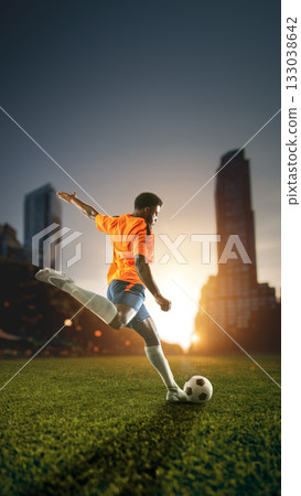 Soccer player shooting ball with city skyline at sunrise. Handmade collage 133038642