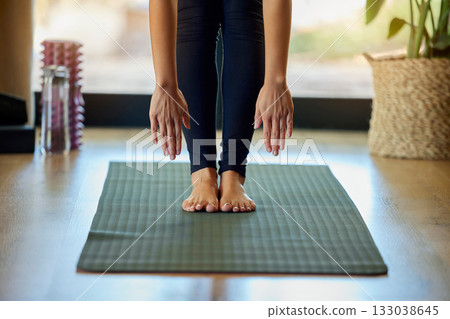Hands, feet and yoga with a woman in her home for a mental health, fitness or wellness workout. Exercise, pilates or stretching and a female yogi training with a forward bend alone for zen 133038645