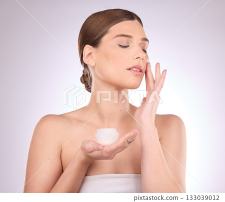 Beauty, skincare or woman with face cream product in daily grooming treatment with makeup cosmetics in studio. Dermatology, mockup space background or girl model applying facial sunscreen lotion Beauty, skincare or woman with face cream product in daily grooming treatment with makeup cosmetics in studio. Dermatology, mockup space background or girl model applying facial sunscreen lotion 133039012
