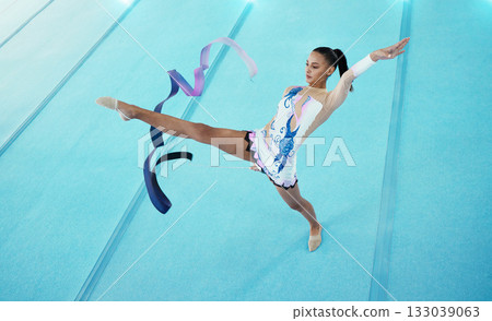 Gymnastics, woman is dancing with ribbon and performance, flexibility with professional athlete in gym and top view. Rhythmic gymnast, leg in air with fitness, grace and action, dance and sports 133039063