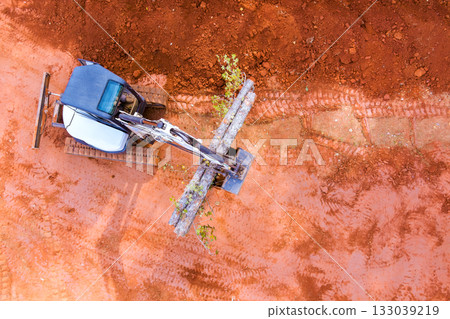 Construction equipment clearing land for new project on red dirt 133039219