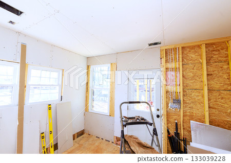 Interior renovation in bright room with exposed walls tools used for construction project Interior renovation in bright room with exposed walls tools used for construction project 133039228