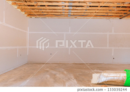 Interior construction site showing unfinished walls, exposed ceiling, construction materials  133039244