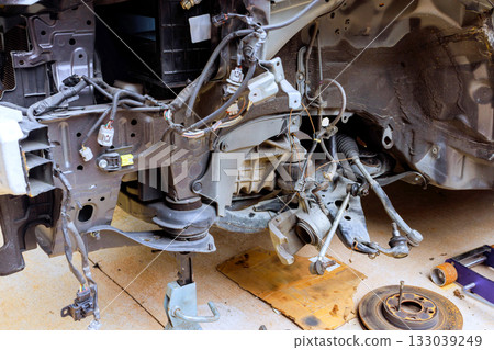 Car suspension system components are removed for repair in garage during works daytime hours 133039249