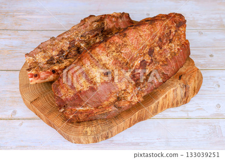 Deliciously cooked ribs served on wooden board ready for barbecue gathering 133039251