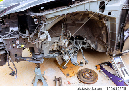 Car parked in driveway with open hood exposing engine components during maintenance 133039256