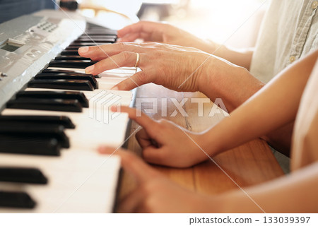 Music lesson, hands of child and piano teacher on keys for development and education together with tutor. Fingers, electric keyboard player and learning musical instrument play for creative children. Music lesson, hands of child and piano teacher on keys for development and education together with tutor. Fingers, electric keyboard player and learning musical instrument play for creative children. 133039397